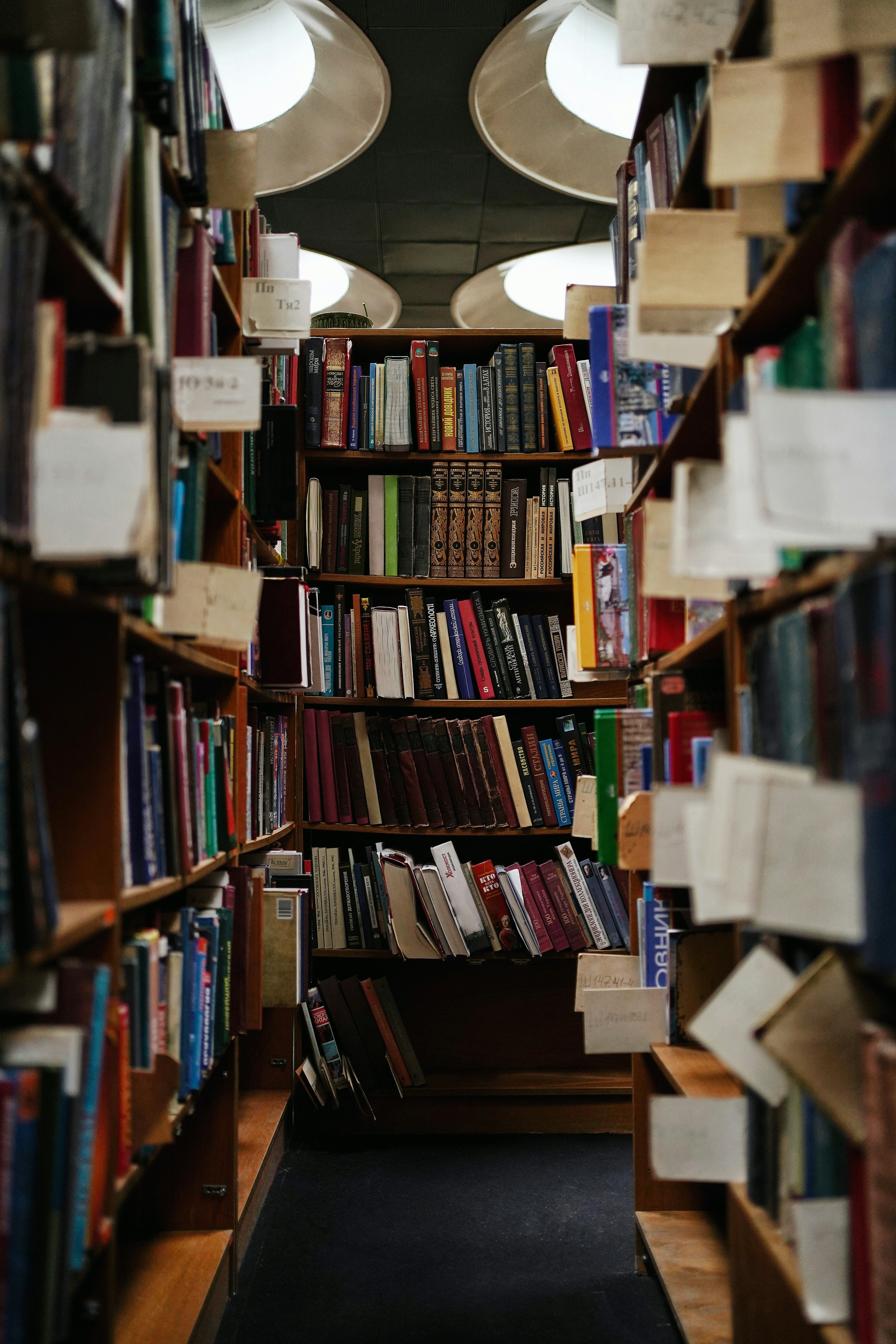 Un pasillo estrecho rodeado de estanterías llenas de libros.