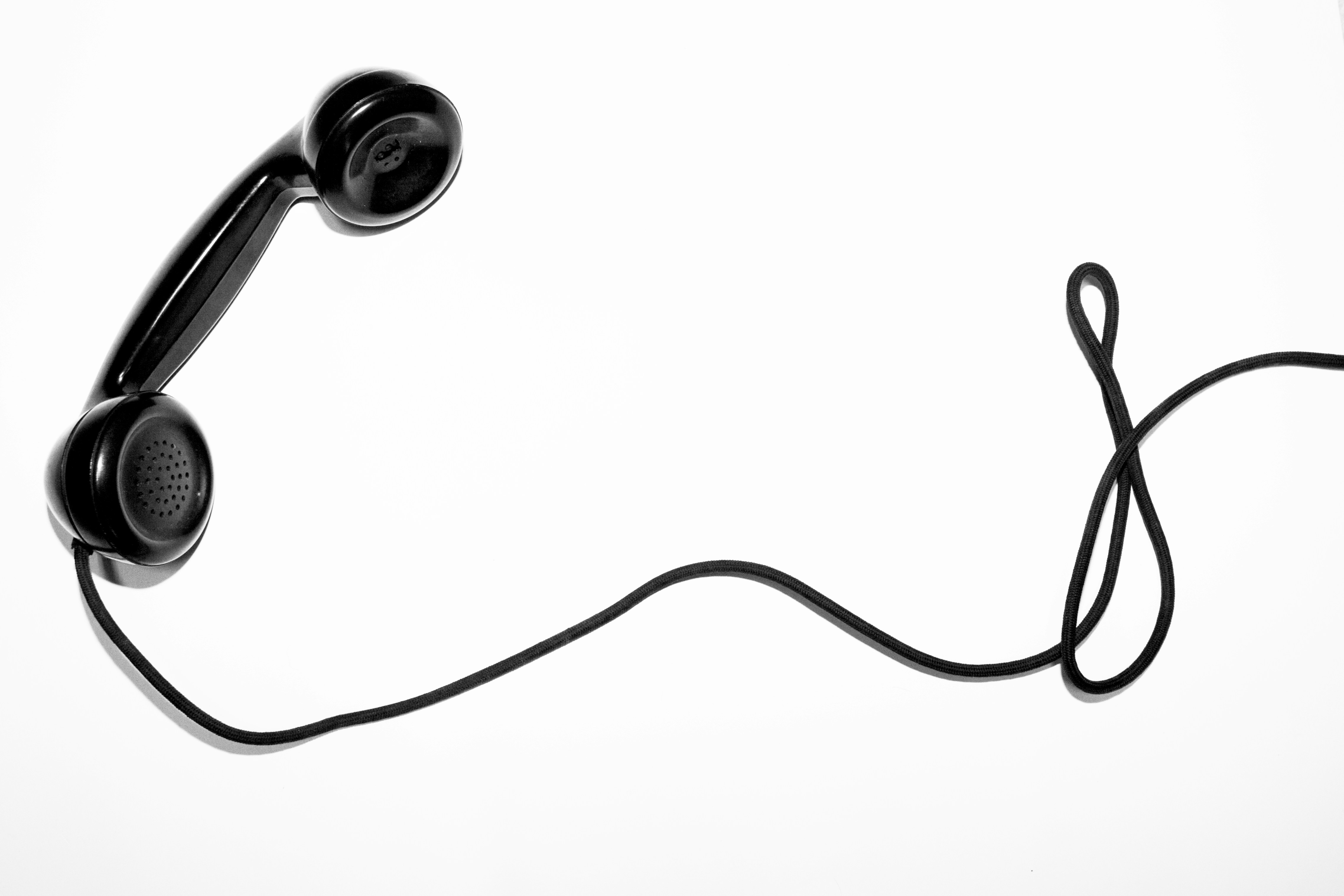 Un teléfono de color negro y estilo clásico descolgado