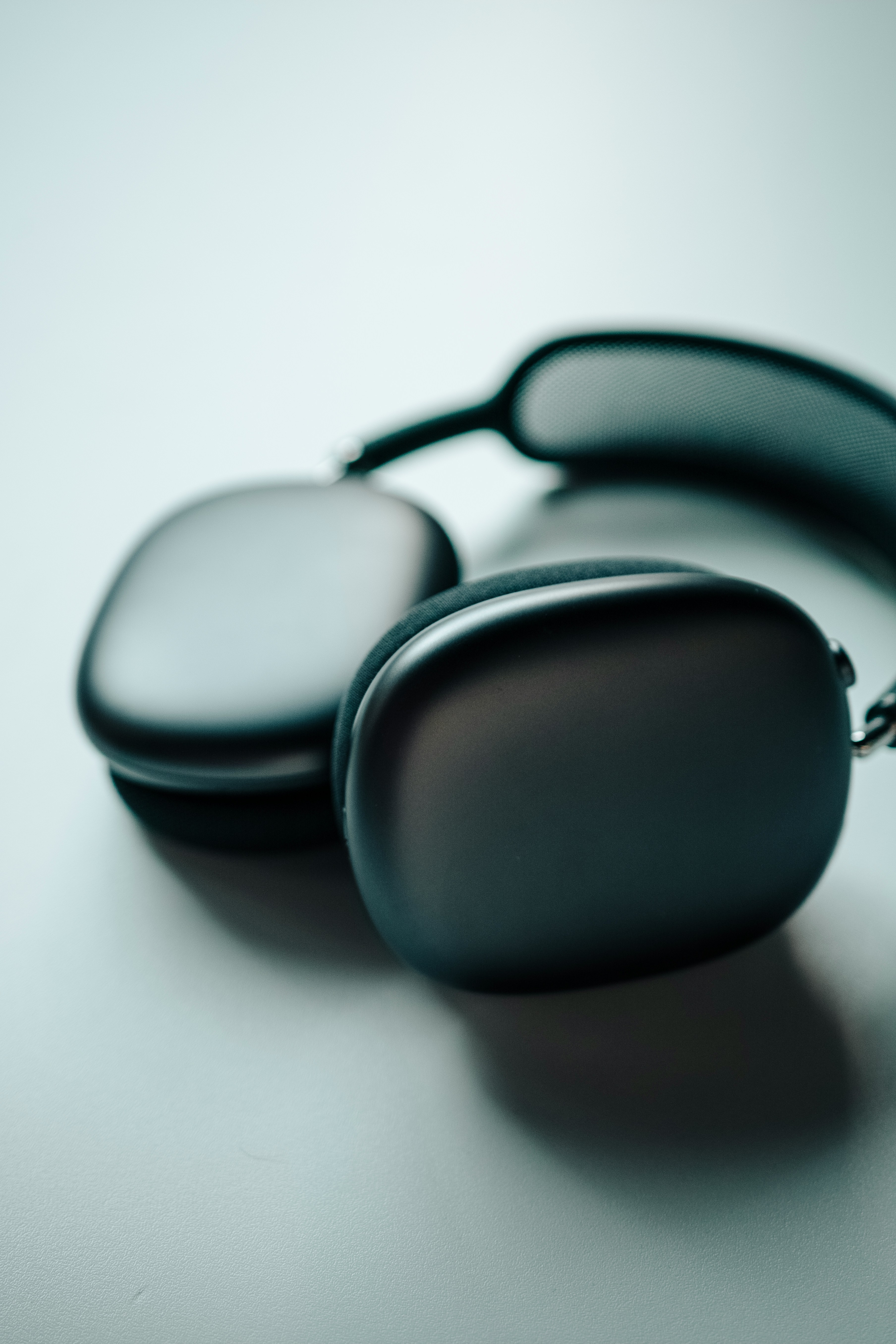 Unos auriculares de color metálico están sobre un fondo blanco.